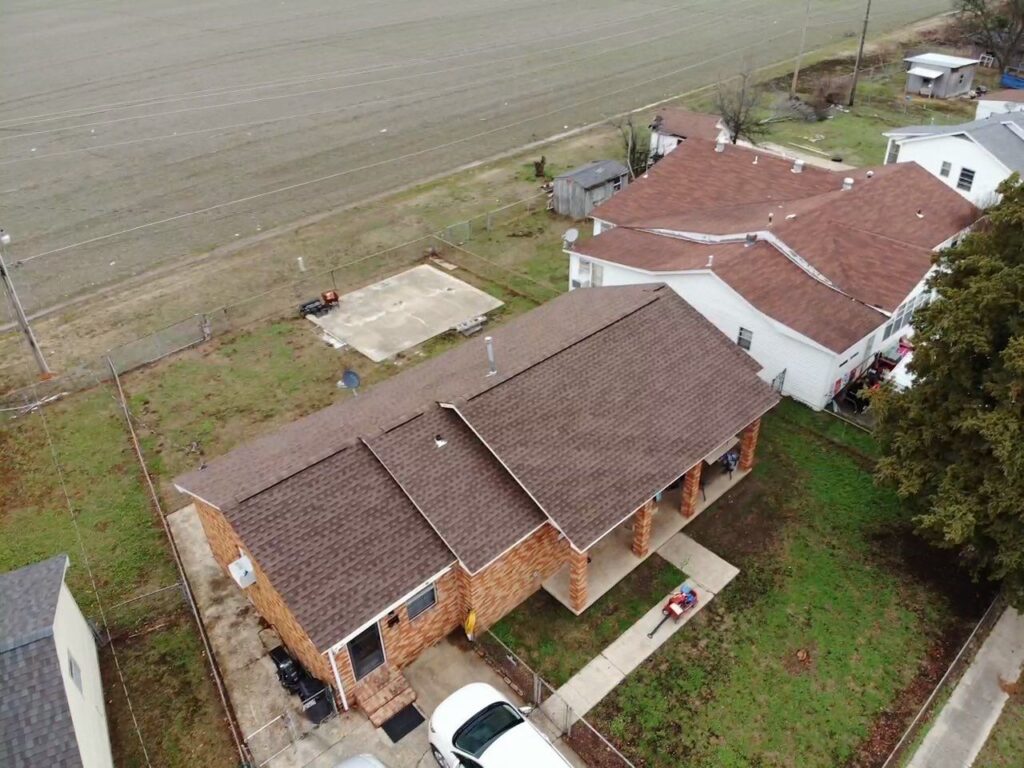 Aerial view of home with shingle roof.